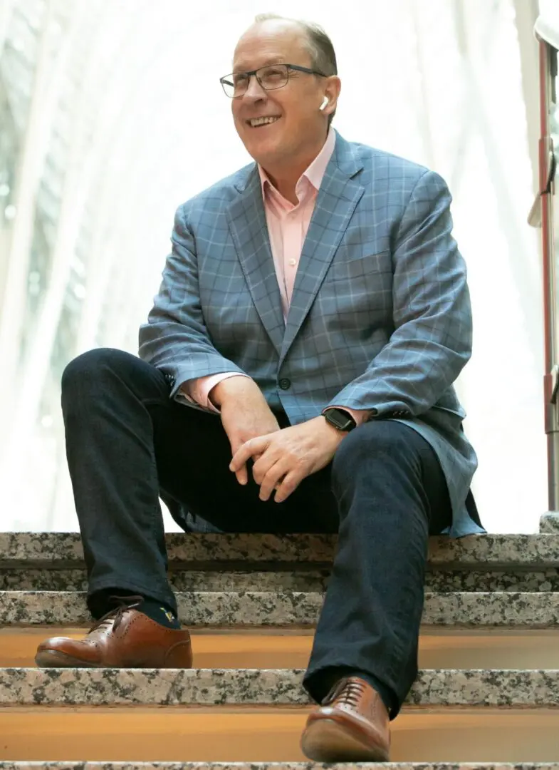 A man sitting on the ground wearing a suit and tie.